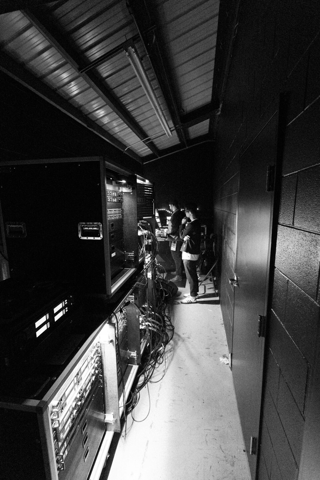 Broadcast control room with rows of video monitors and engineers